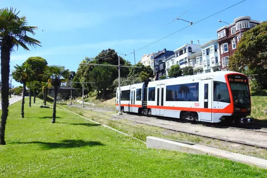 A MUNI passenger train runs along a track in San Francisco.