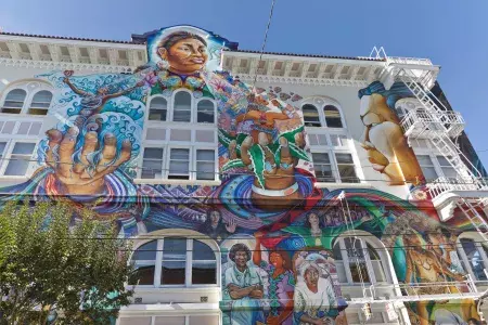 A colorful, large-scale mural covers the side of the Women's Building in San Francisco's Mission District.