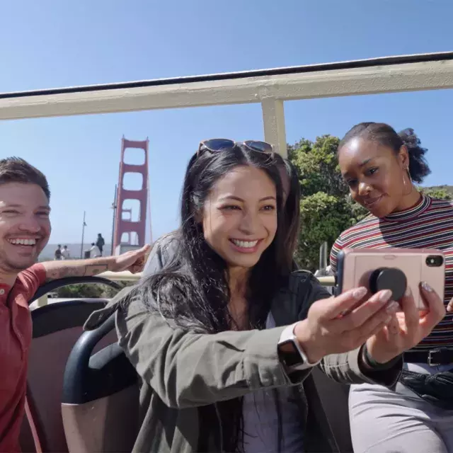 A group of visitors take a selfie on a bus tour near the Golden Gate Bridge. San Francisco, CA.